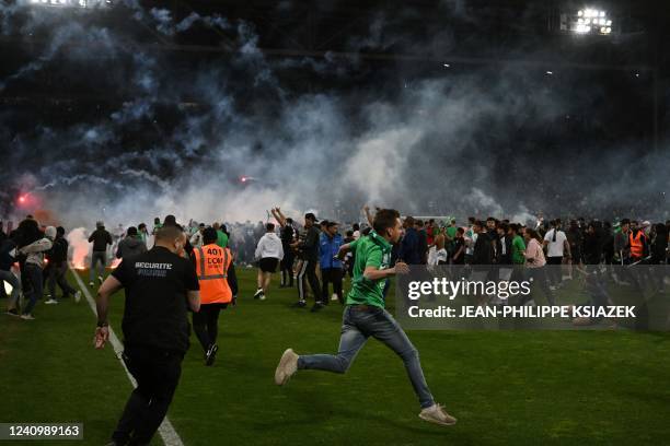 Saint-Etienne's fans invade the pitch after being defeated at the end of the French L1-L2 play-off second leg football match between AS Saint-Etienne...