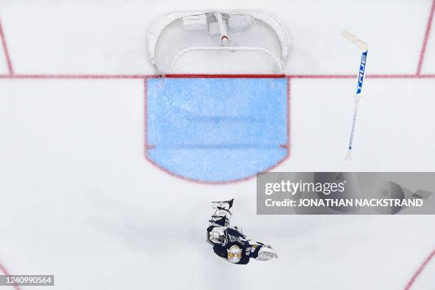 Finland's goalkeeper Jussi Olkinuora reacts as his team win at overtime during the IIHF Ice Hockey World Championships final match between Finland...