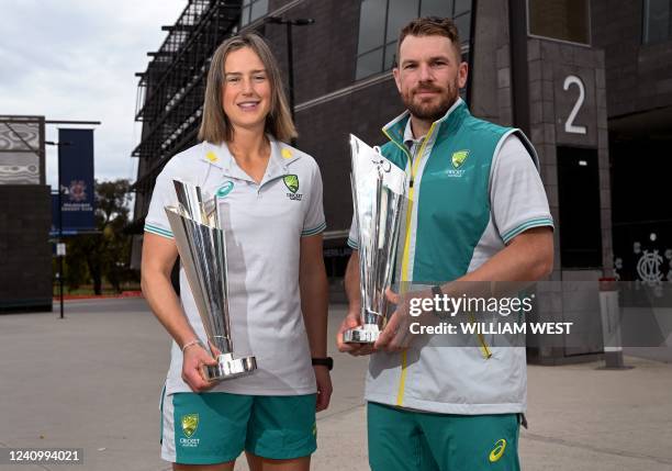 Australian cricketers Ellyse Perry and Aaron Finch pose with the men's and women's cricket T20 World Cup trophies in Melbourne on May 30 as Cricket...