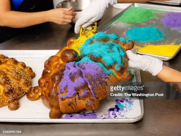 Erica Franco glazes the pan de muerto while Sandra Franco sprinkles the sugar at La Estrella Bakery in Tucson, Arizona on October 19, 2021. La...