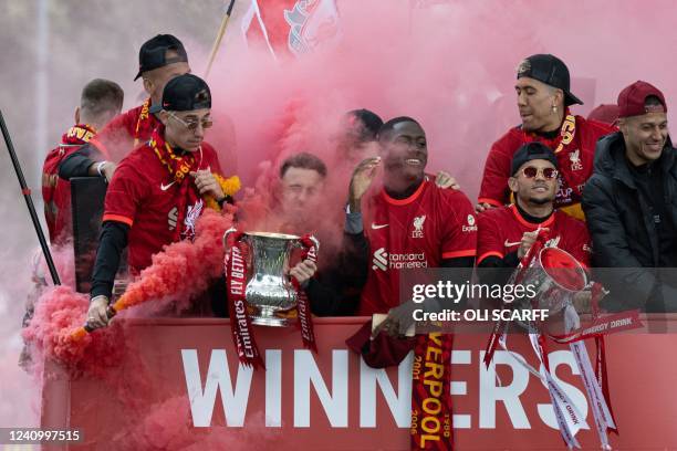 Liverpool's players ride an open-top bus during a parade through the streets of Liverpool in northwest England on May 29, 2022 to celebrate winning...