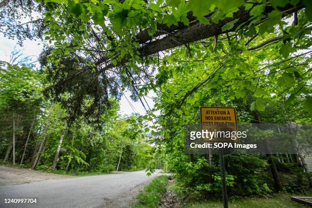 Sign made to slow down vehicles is seen below a fallen tree. The storm on the 21st of May in the province of Quebec left a trail of destruction...