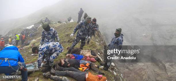 Armed Police Force, Rescue team carry the bodies of the passengers from the crash site of Tara Air at the hilly area of Thasang village of Mustang...