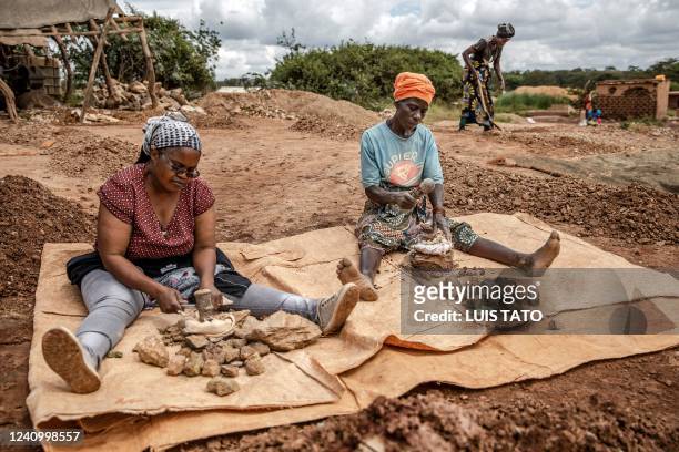 Tanzanian miners Stella Frank Ungani and Tabu Maduhu breaking stones containing gold grains at a gold processing area near mines in Nyarugusu, Geita...