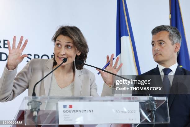 French Sports, Olympic and Paralympic Games Minister Amelie Oudea-Castera gestures next to French Interior Minister Gerald Darmanin during a press...