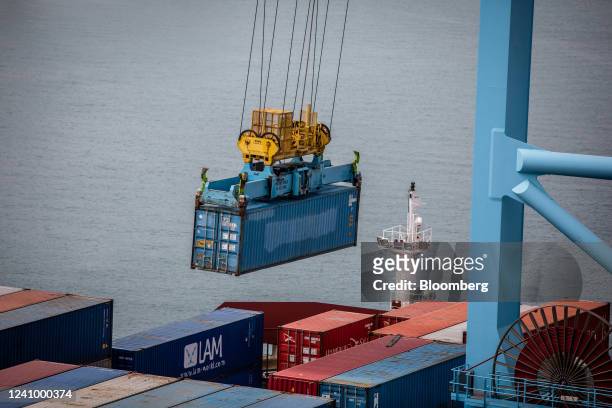 Gantry crane loads shipping containers onto a vessel at the Muelle Sur terminal, operated by APM Terminals, at the Port of Barcelona in Barcelona,...