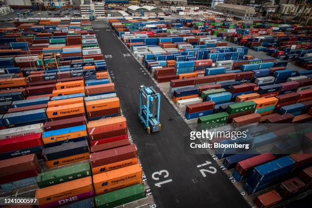 Crane transports a shipping container at the Muelle Sur terminal, operated by APM Terminals, at the Port of Barcelona in Barcelona, Spain, on Friday,...
