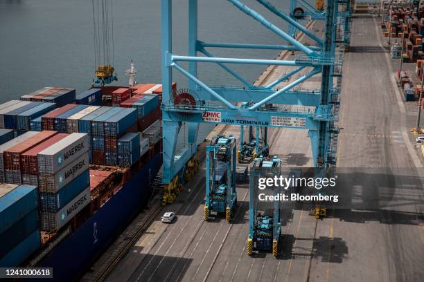 Gantry crane loads shipping containers onto a vessel at the Muelle Sur terminal, operated by APM Terminals, at the Port of Barcelona in Barcelona,...