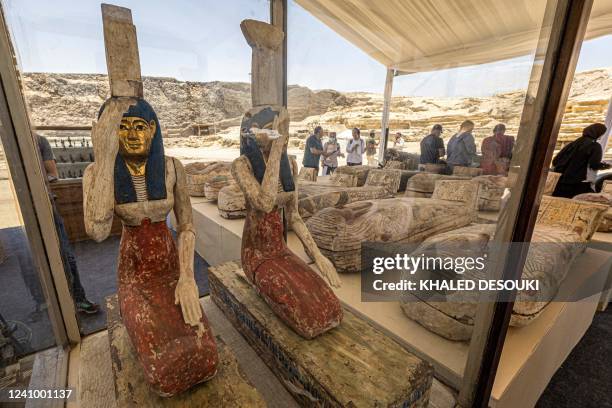 Statuettes depicting the Egyptian goddesses Isis and Nephthys and other sarcophaguses found in a cache dating to the Egyptian Late Period are...