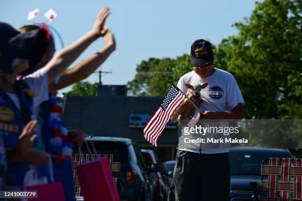 Man holds his dog and a U.S. Flag while watching a Memorial Day Parade on May 30, 2022 in Egg Harbor Township, New Jersey. Memorial Day events are...