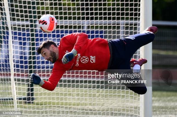 France's goalkeeper Hugo Lloris jumps for the ball during a training session in Clairefontaine-en-Yvelines on May 30, 2022 as part of the team's...