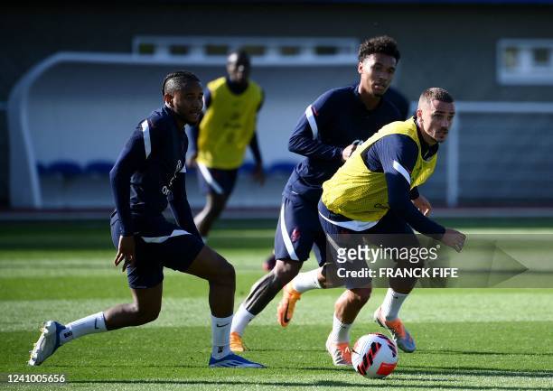 France's defender Jules Kounde and Boubacar Kamara fights for the ball with France's forward Antoine Griezmann during a training session in...