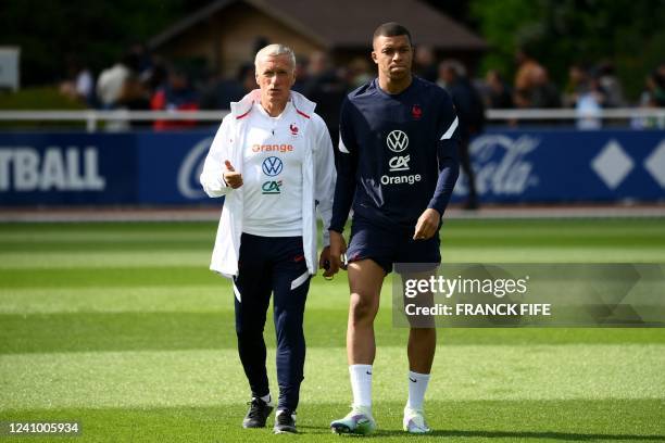 France's head coach Didier Deschamps chats with France's forward Kylian Mbappe during a training session in Clairefontaine-en-Yvelines on May 30,...