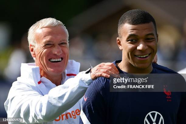 France's head coach Didier Deschamps jokes with France's forward Kylian Mbappe during a training session in Clairefontaine-en-Yvelines on May 30,...