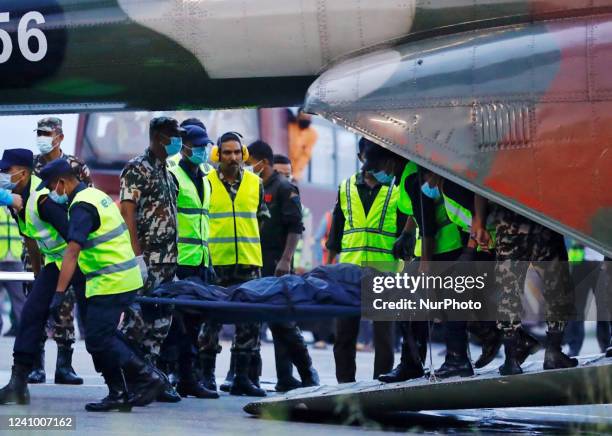Nepalese soliders carry the body of a victim killed in a Tara Air plane crash as it arrives in Kathmandu , Nepal, Monday, May 30, 2022. The...