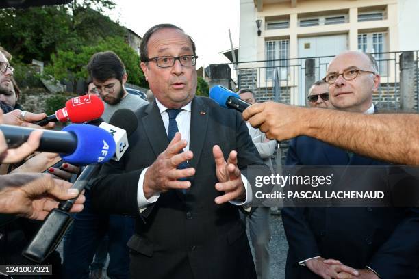 French former President Francois Hollande talks to the press next to former Prime minister Bernard Cazeneuve during a visit to support local...