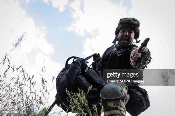 Ukrainian soldier leans out his hand to rescue a journalist hiding in a ditch from Russian artillery strikes at the bridge connecting Severodoonetsk...