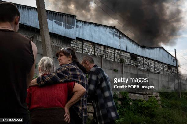 Woman hugs her mother while they observe the chain of black smoke from a bus depot caused by Russian artillery strikes in Lysychansk, Luhansk. As...