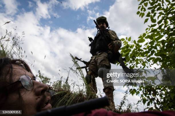 Ukrainian soldier rescues a journalist hiding in a ditch from Russian artillery strikes at the bridge connecting Severodoonetsk and Lysychansk,...