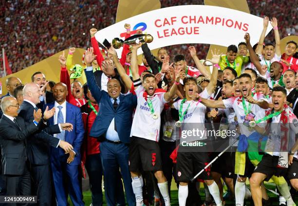 Wydad's midfielder Yahya Jabrane lifts the trophy as he celebrates with his teammates after winning the CAF Champions League Semi-Final between...