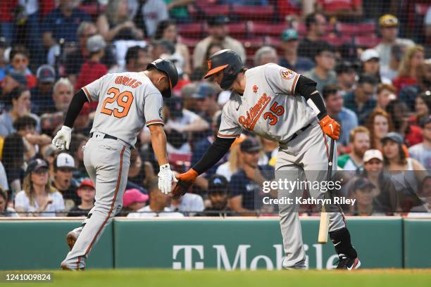 Ramon Urias high fives Adley Rutschman of the Baltimore Orioles after hitting a two run home run in the third inning against the Boston Red Sox at...