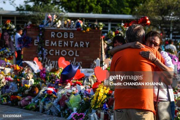 Woman cries at a makeshift memorial at Robb Elementary School in Uvalde, Texas, on May 30, 2022. - Grieving families were to hold the first funerals...