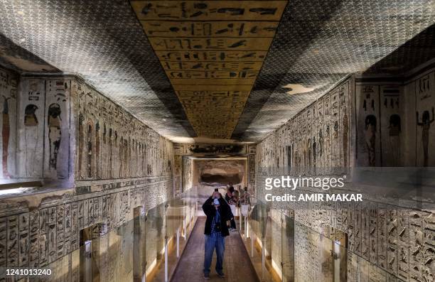 Visitor takes pictures of the hieroglyph-adorned walls and ceiling in KV11, the Tomb of Pharaoh Ramses III , at the Valley of the Kings on the West...