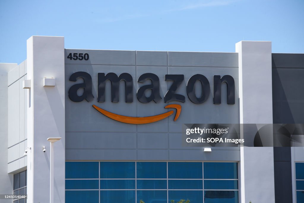 An Amazon An Amazon logo is displayed on a fulfillment center. Being the... News ...