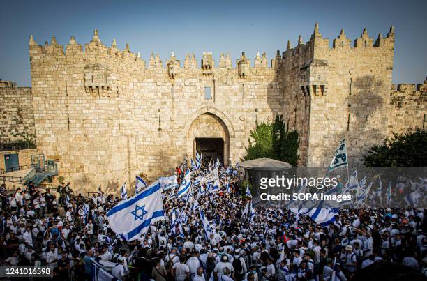 Israeli right-wing youths chant slogans while waving flags at Damascus gate in Jerusalem. Around 70,000 Jewish nationalists marched through and...