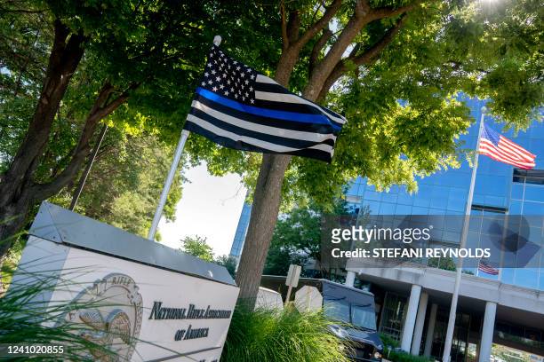 Thin blue line" flag, signaling support for law enforcement, is displayed above the sign for the National Rifle Association outside of its...