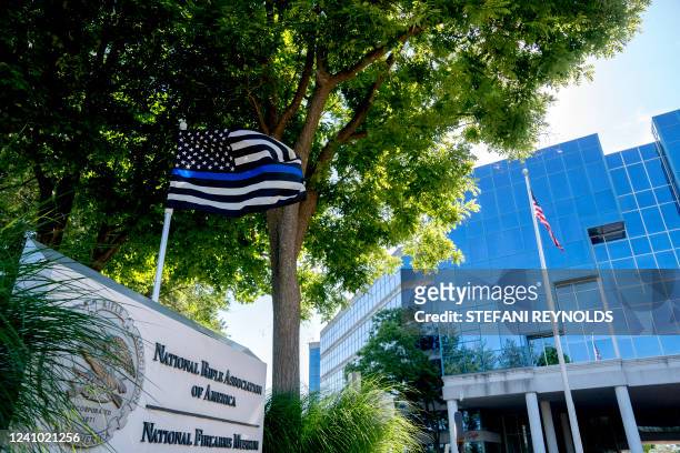 Thin blue line" flag, signaling support for law enforcement, is displayed above the sign for the National Rifle Association outside of its...