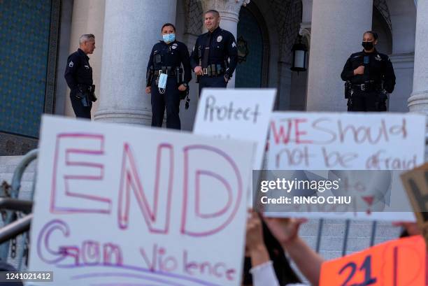 Police officers watch as students participate in a school walk-out and protest in front of City Hall to condemn gun violence, in Los Angeles,...