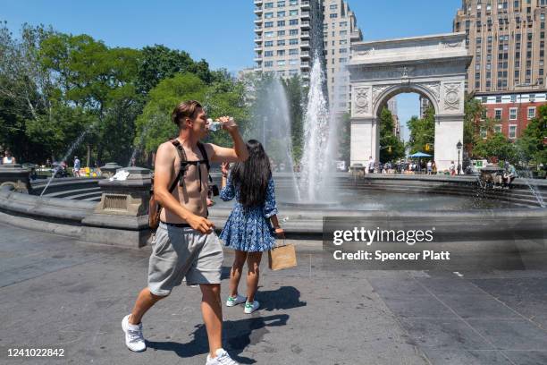 Man walks through Washington Square Park in Manhattan on May 31, 2022 in New York City. Temperatures reached the 90s today and are expected to stay...