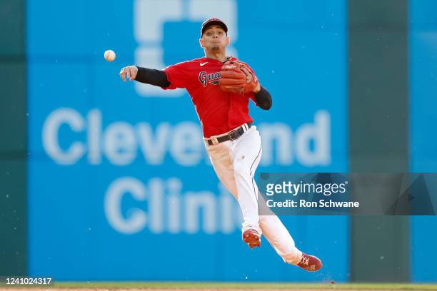 Andres Gimenez of the Cleveland Guardians throws out Whit Merrifield of the Kansas City Royals at first base during the fifth inning at Progressive...
