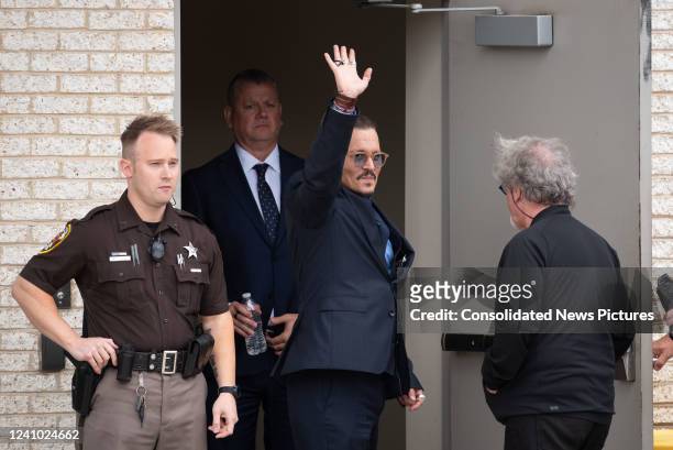 Johnny Depp waves to his fans during a recess outside court during the Johnny Depp and Amber Heard civil trial at Fairfax County Circuit Court on May...