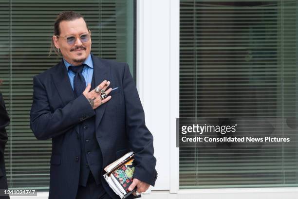 Johnny Depp gestures to fans during a recess outside court during the Johnny Depp and Amber Heard civil trial at Fairfax County Circuit Court on May...