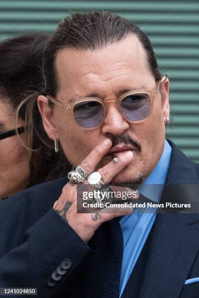 Johnny Depp smokes a cigarette during a recess outside court during the Johnny Depp and Amber Heard civil trial at Fairfax County Circuit Court on...