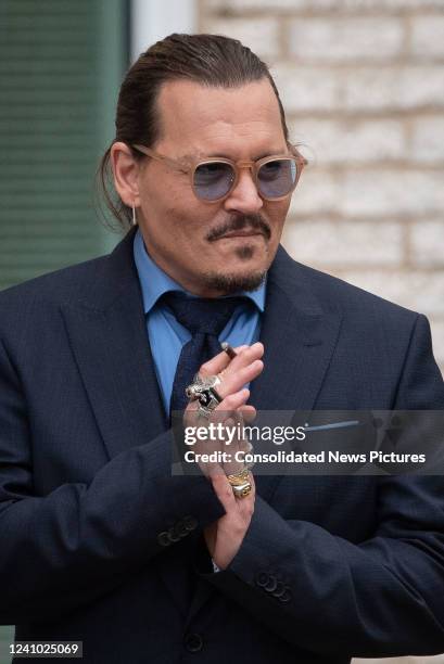 Johnny Depp gestures to his fans during a recess outside court during the Johnny Depp and Amber Heard civil trial at Fairfax County Circuit Court on...
