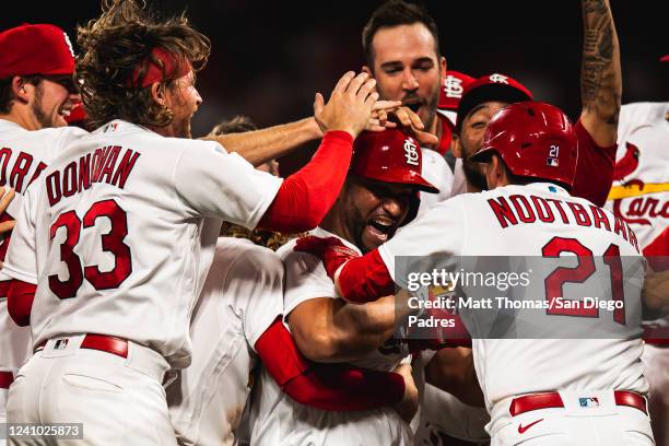 Players celebrate with Albert Pujols of the St. Louis Cardinals after Pujols hit a walk-off sacrifice fly ball in the tenth inning against the San...