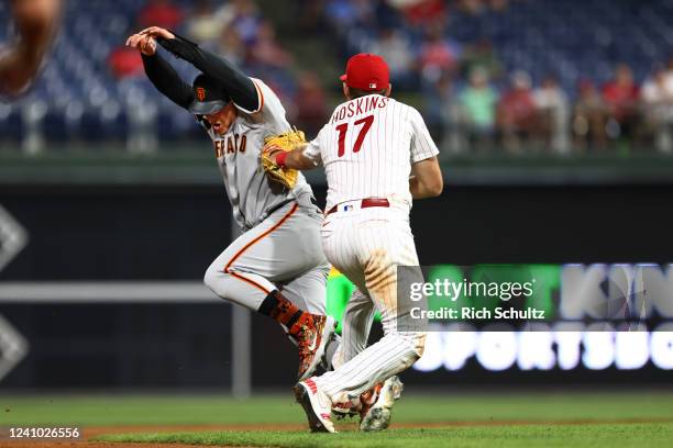Joc Pederson of the San Francisco Giants is tagged out by first baseman Rhys Hoskins of the Philadelphia Phillies after getting caught in a rundown...