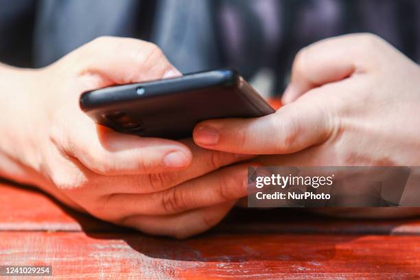 Person uses a mobile phone in Krakow, Poland, on May 30, 2022.