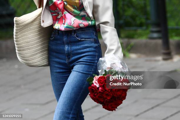 Woman carries a bouquet of roses in Krakow, Poland, on May 30, 2022.