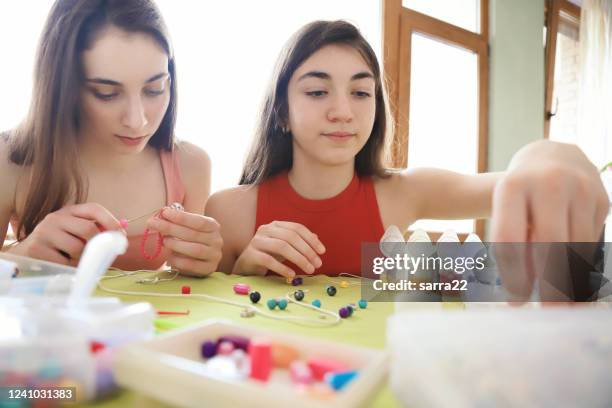 jovens fazendo pulseiras de contas - bead - fotografias e filmes do acervo