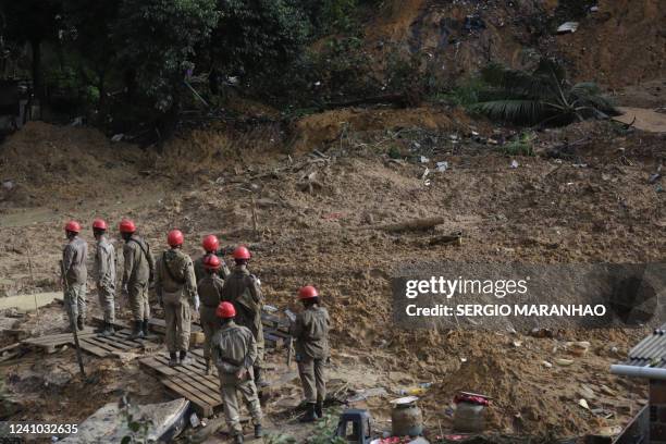 Firefighters stand amid mud after a landslide caused by heavy rains in the community Vila dos Milagres, Barro neighbourhood, in Recife, Pernambuco...