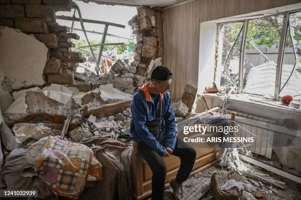 Sergiy Tarasyuk sits on his bed in his destroyed house after a missile strike in the city of Sloviansk in the eastern Ukrainian region of Donbas on...