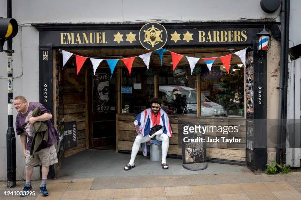 Knitted bunting hangs outside a barber shop ahead of the Platinum Jubilee of Queen Elizabeth II on June 1, 2022 in Beccles, England. The people of...