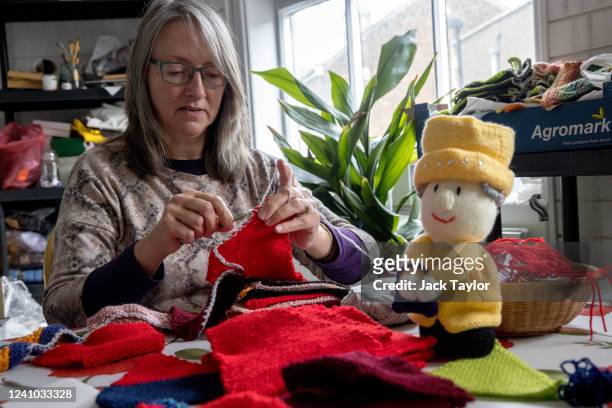 Caroline Topping crochets and knits bunting beside a knitted model of Queen Elizabeth II at the Beccles Community Hub on June 1, 2022 in Beccles,...