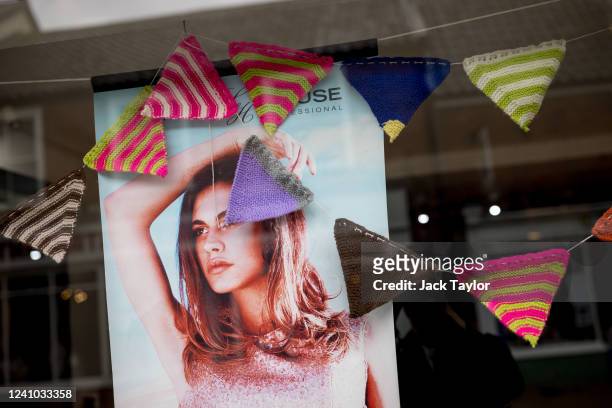 Knitted bunting hangs inside a beauty parlour ahead of the Platinum Jubilee of Queen Elizabeth II on June 1, 2022 in Beccles, England. The people of...