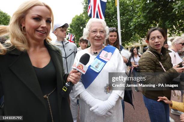 Lookalike of Queen Elizabeth II, walks down The Mall near Buckingham Palace, London, where well-wishers are already camping out for the best spots to...