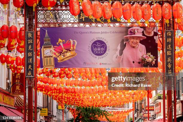Days before the Queen's Platinum Jubilee celebrations commence over the Bank Holiday acros the UK, a banner showing her face hangs among Chinese...